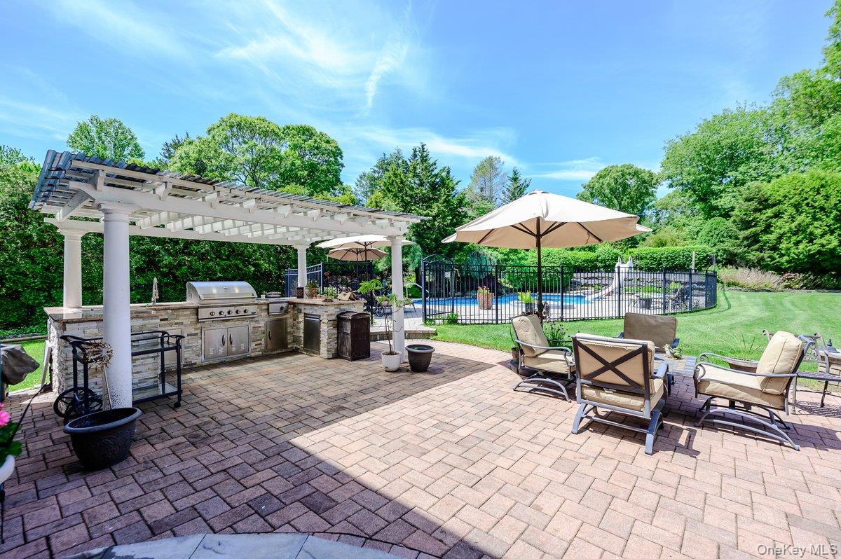 129 Round Swamp Road Huntington, NY 11743 - Photo 40 of 49 Paver patio featuring a built-in outdoor kitchen with a stainless steel grill, stone facade, and a white pergola