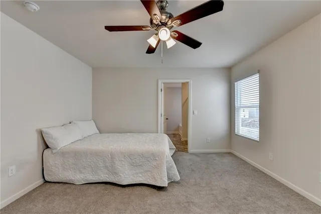 a bedroom with a bed chandelier and window