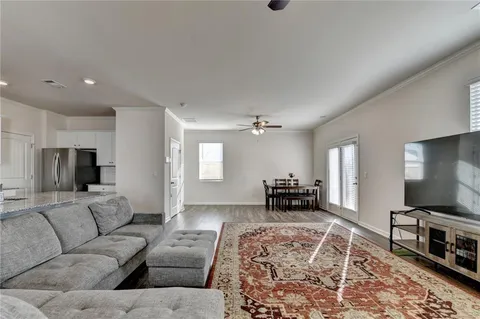a living room with furniture and a flat screen tv with wooden floor