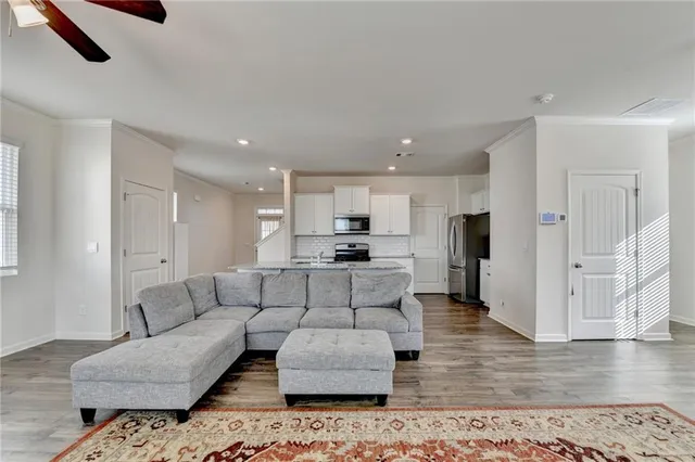 a living room with furniture and kitchen view