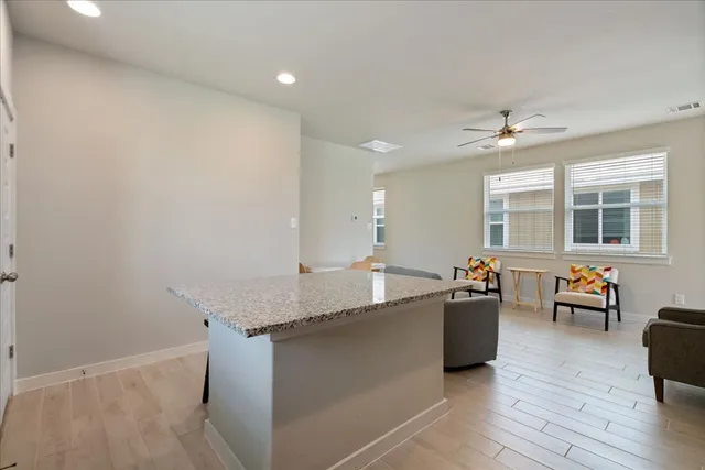 a living room with granite countertop furniture a couch and wooden floor