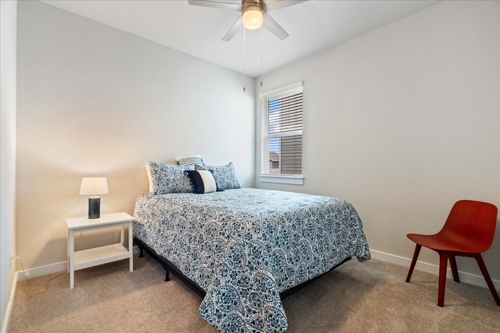 330 Hortus Drive Kyle, TX 78640 - Photo 16 of 26 a bedroom with a bed and a chandelier