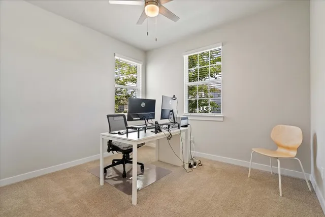 a view of a workspace with furniture and a window