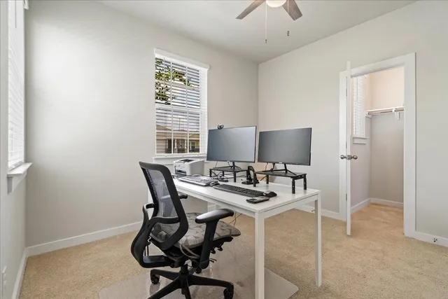 a view of a workspace with furniture and a window