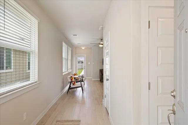 a view of a hallway with wooden floor and furniture