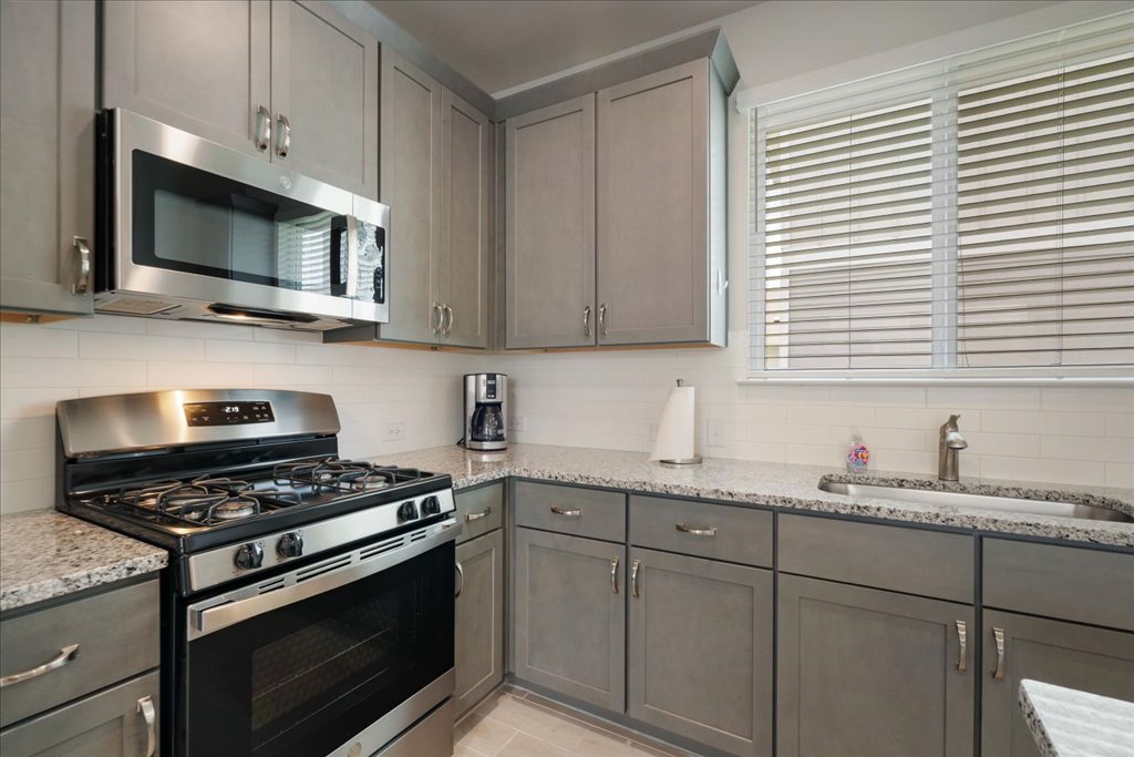 330 Hortus Drive Kyle, TX 78640 - Photo 10 of 26 a kitchen with stainless steel appliances white cabinets granite counter tops and a window