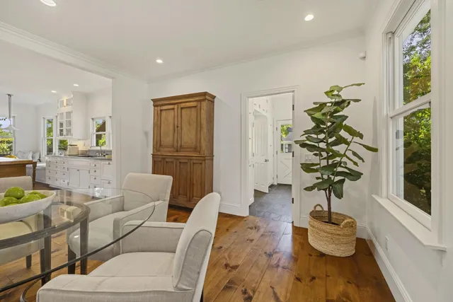 a living room with furniture and a painting next to a window