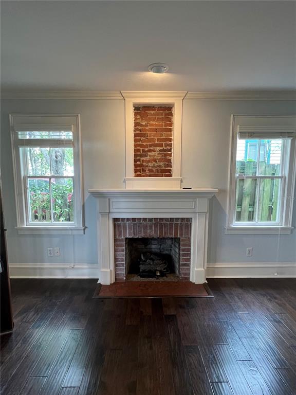 433 Southeast 7th Street Gainesville, FL 32601 - Photo 12 of 28 an empty room with wooden floor a fireplace and windows