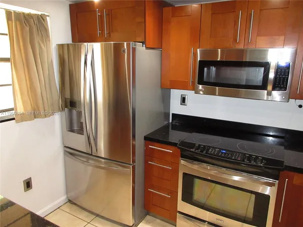 a kitchen with granite countertop a sink a stove and cabinets