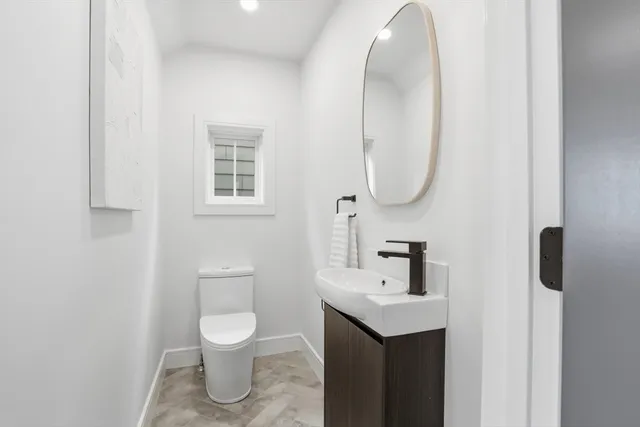 a bathroom with a toilet a sink and mirror