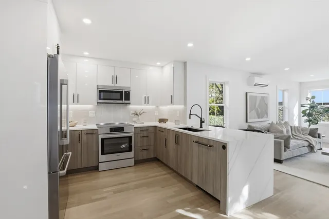 a large kitchen with stainless steel appliances lots of counter space sink and a refrigerator