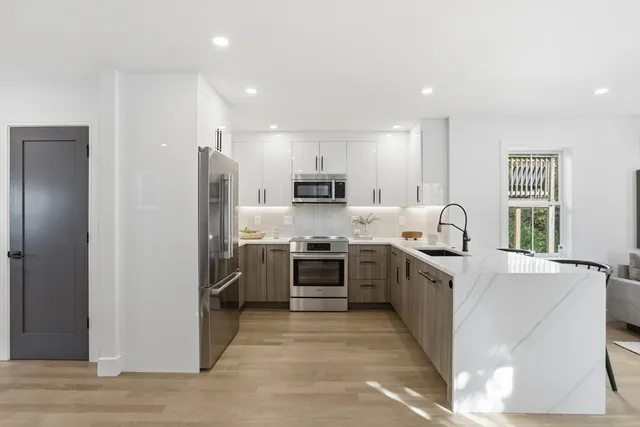 a kitchen with stainless steel appliances granite countertop a refrigerator and a stove top oven