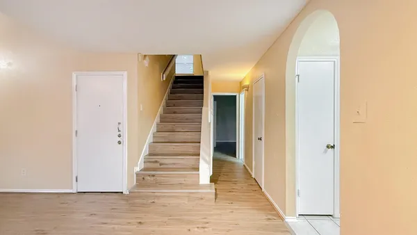 a view of a hallway with wooden floor and entryway