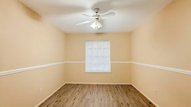 an empty room with a window and a ceiling fan