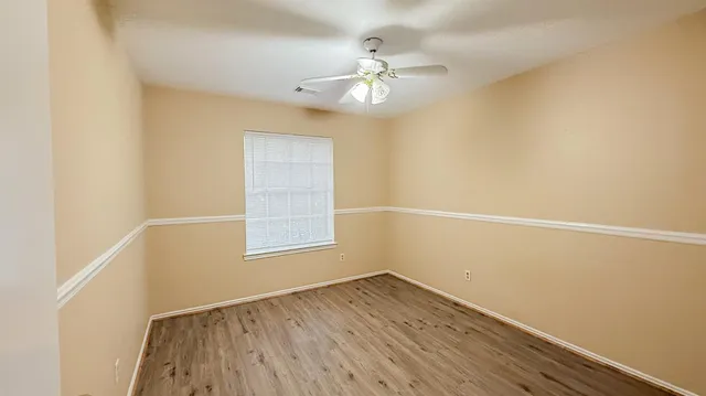 an empty room with a window and wooden floor