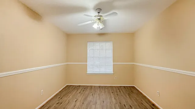 an empty room with a window and a fan
