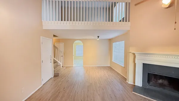 a view of a livingroom with wooden floor and a fireplace