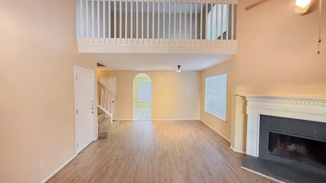 a view of a livingroom with wooden floor and a fireplace