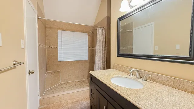 a bathroom with a granite countertop sink and a mirror