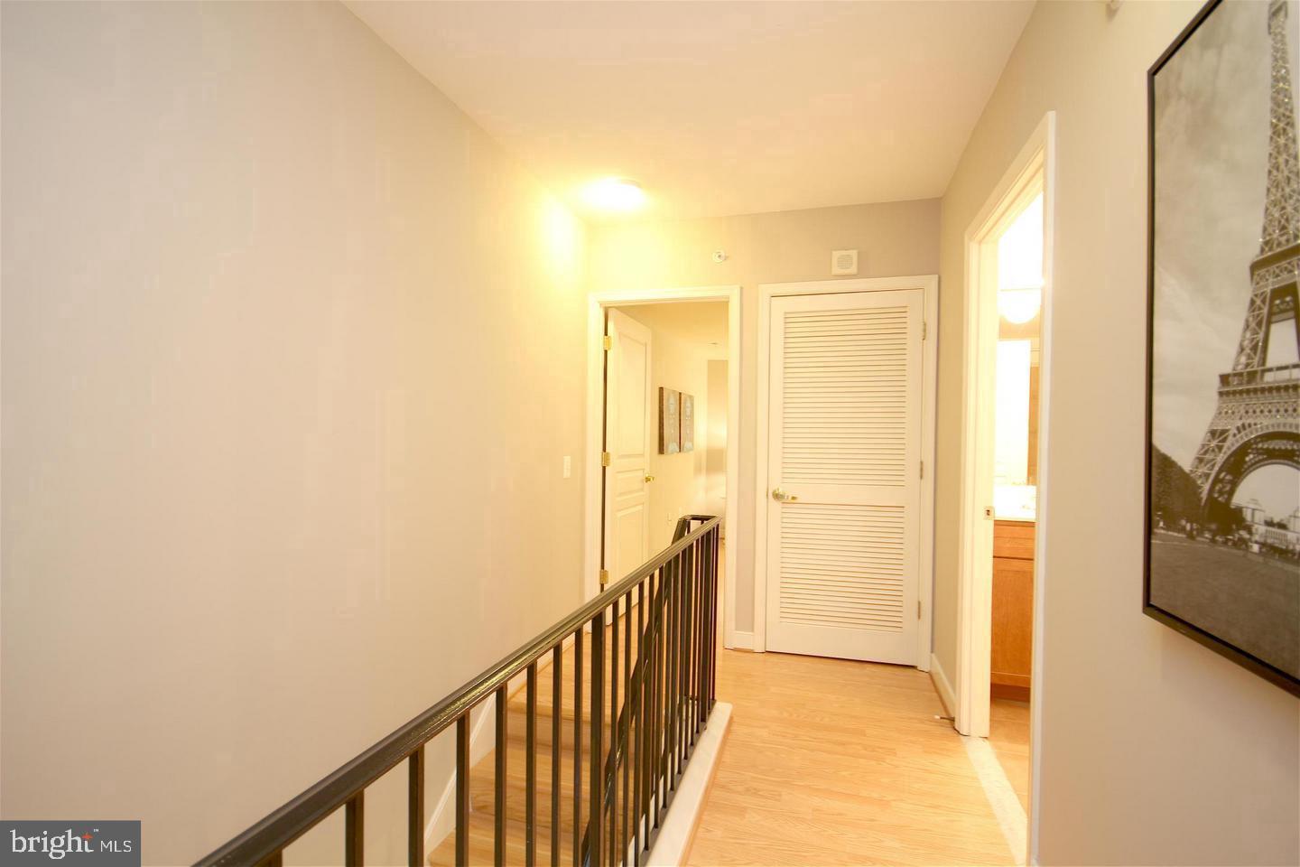 616 E Street Northwest, Unit 246 Washington, DC 20004 - Photo 14 of 40 a view of a hallway with wooden floor and a bathroom