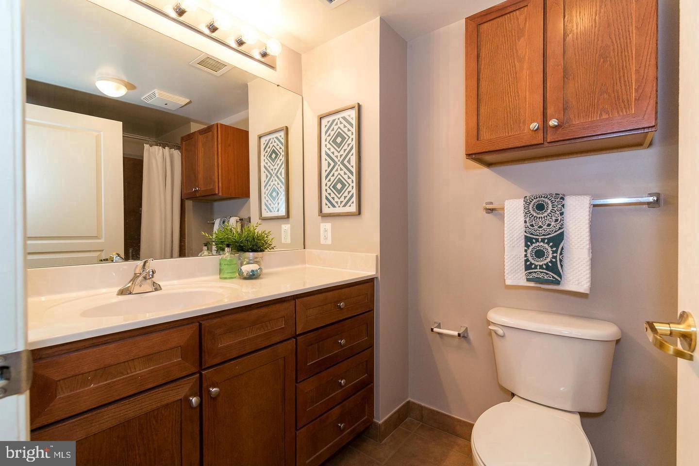 616 E Street Northwest, Unit 246 Washington, DC 20004 - Photo 18 of 40 a bathroom with a toilet sink and mirror