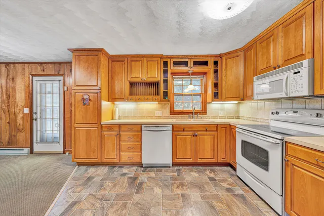 a kitchen with stainless steel appliances granite countertop a stove a sink dishwasher a refrigerator and cabinets with wooden floor