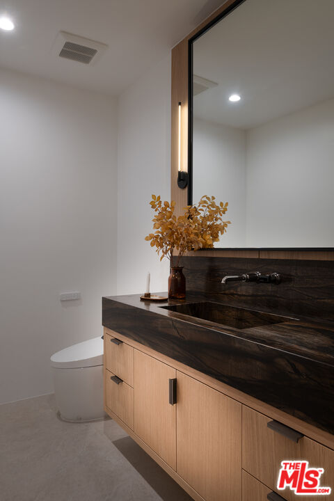 23615 Long Valley Road Hidden Hills, CA 91302 - Photo 57 of 75 a bathroom with a granite countertop sink and a mirror