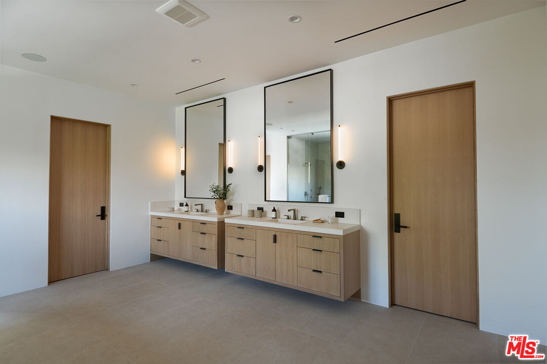 23615 Long Valley Road Hidden Hills, CA 91302 - Photo 64 of 75 a bathroom with double vanity sink a mirror and a bathtub