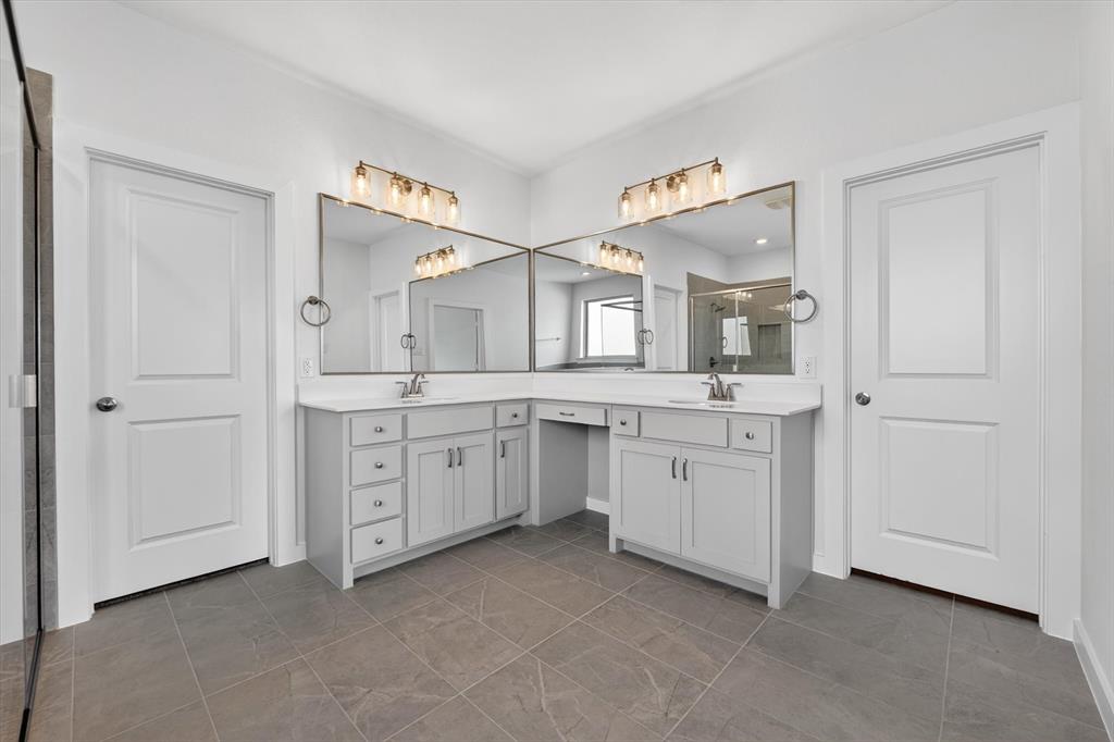 416 McAlpine Drive Springtown, TX 76082 - Photo 24 of 40 Dual vanity with white countertops and light gray cabinetry, large wall-mounted mirrors, and contemporary light fixtures