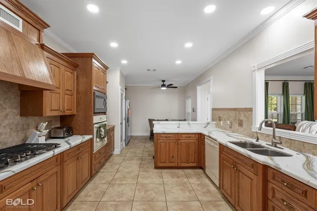 a large kitchen with stainless steel appliances granite countertop a sink and cabinets