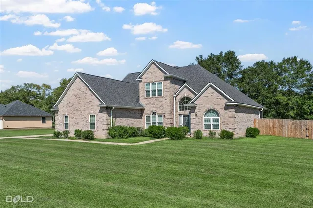 a front view of house with yard and green space
