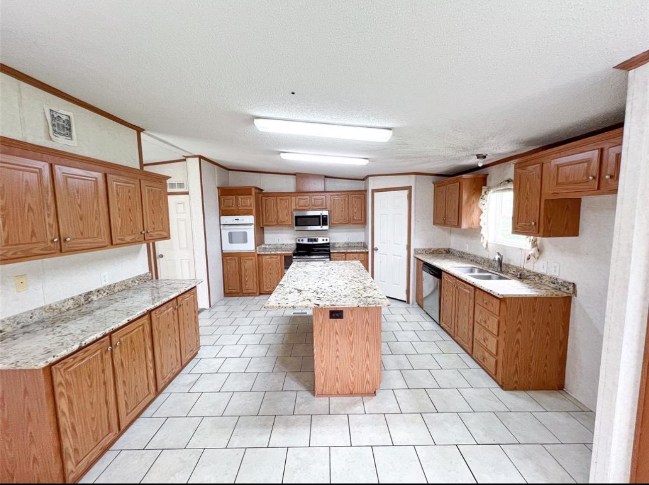 24450 Cunningham Drive Porter, TX 77365 - Photo 4 of 9 a large kitchen with stainless steel appliances granite countertop a stove top oven a sink dishwasher and cabinets