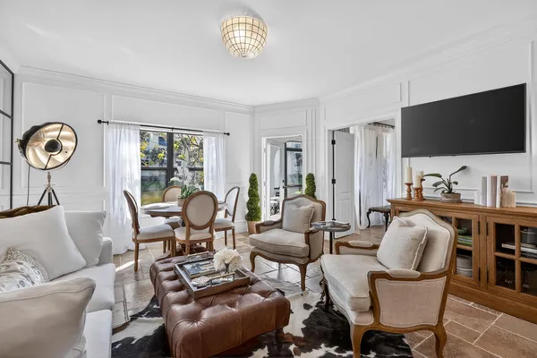 a living room with furniture a flat screen tv and kitchen