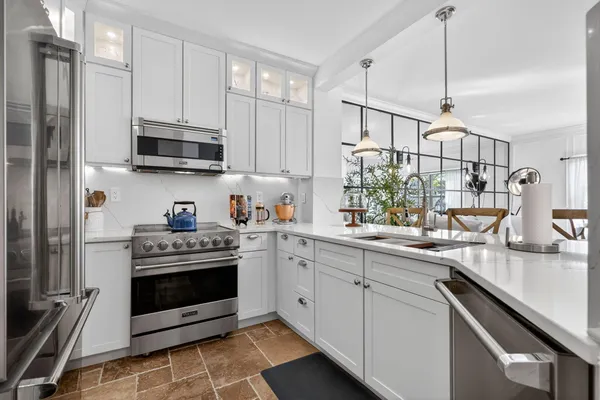 a kitchen with stainless steel appliances granite countertop a stove a sink and a refrigerator