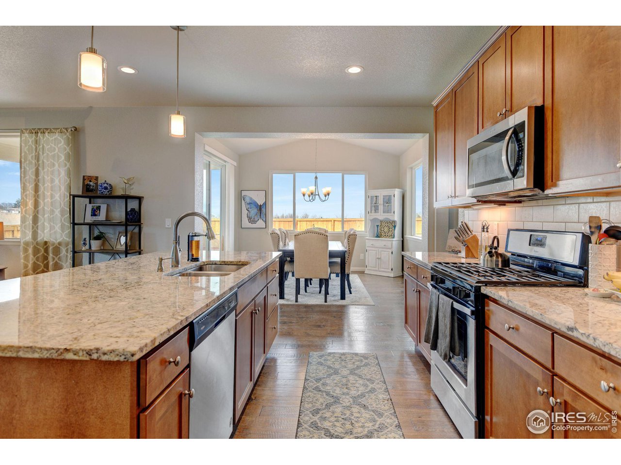 620 Wagon Bend Road Berthoud, CO 80513 - Photo 13 of 39 a kitchen with stainless steel appliances granite countertop a stove top oven a sink a dining table and chairs