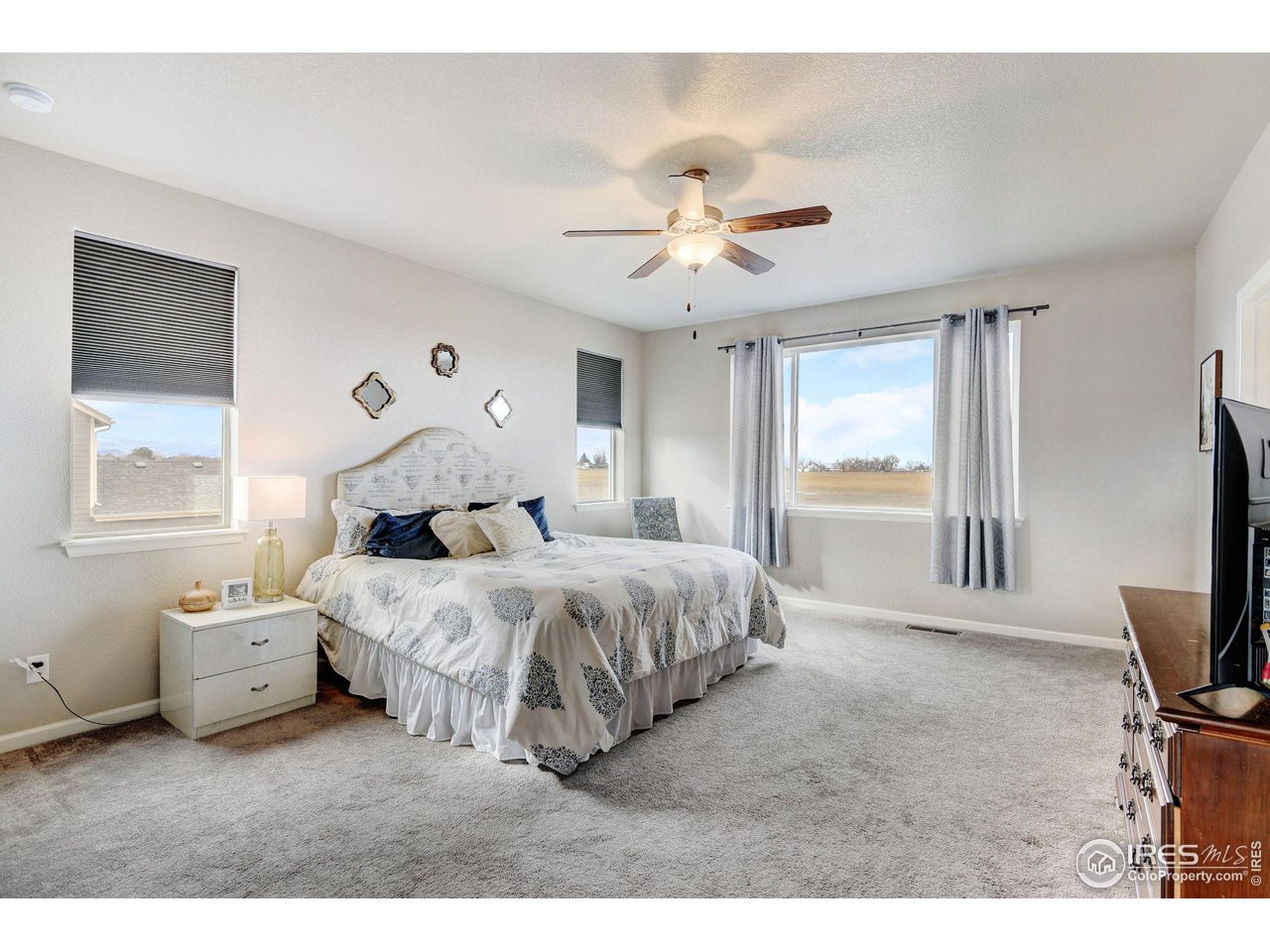 620 Wagon Bend Road Berthoud, CO 80513 - Photo 21 of 39 a bedroom with a bed next to a window with a flat screen tv