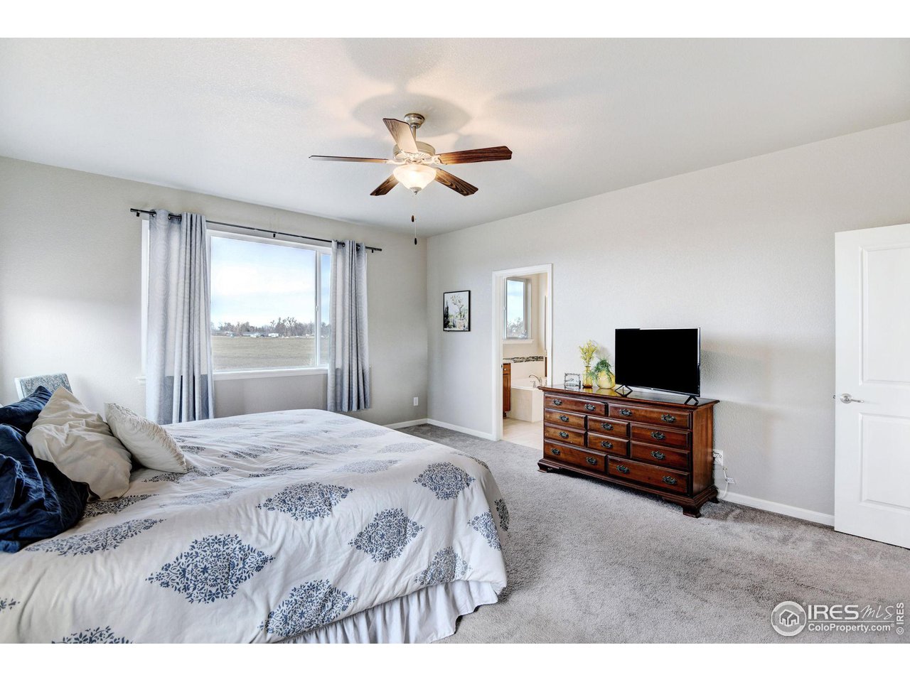 620 Wagon Bend Road Berthoud, CO 80513 - Photo 22 of 39 a bedroom with a bed and a flat screen tv