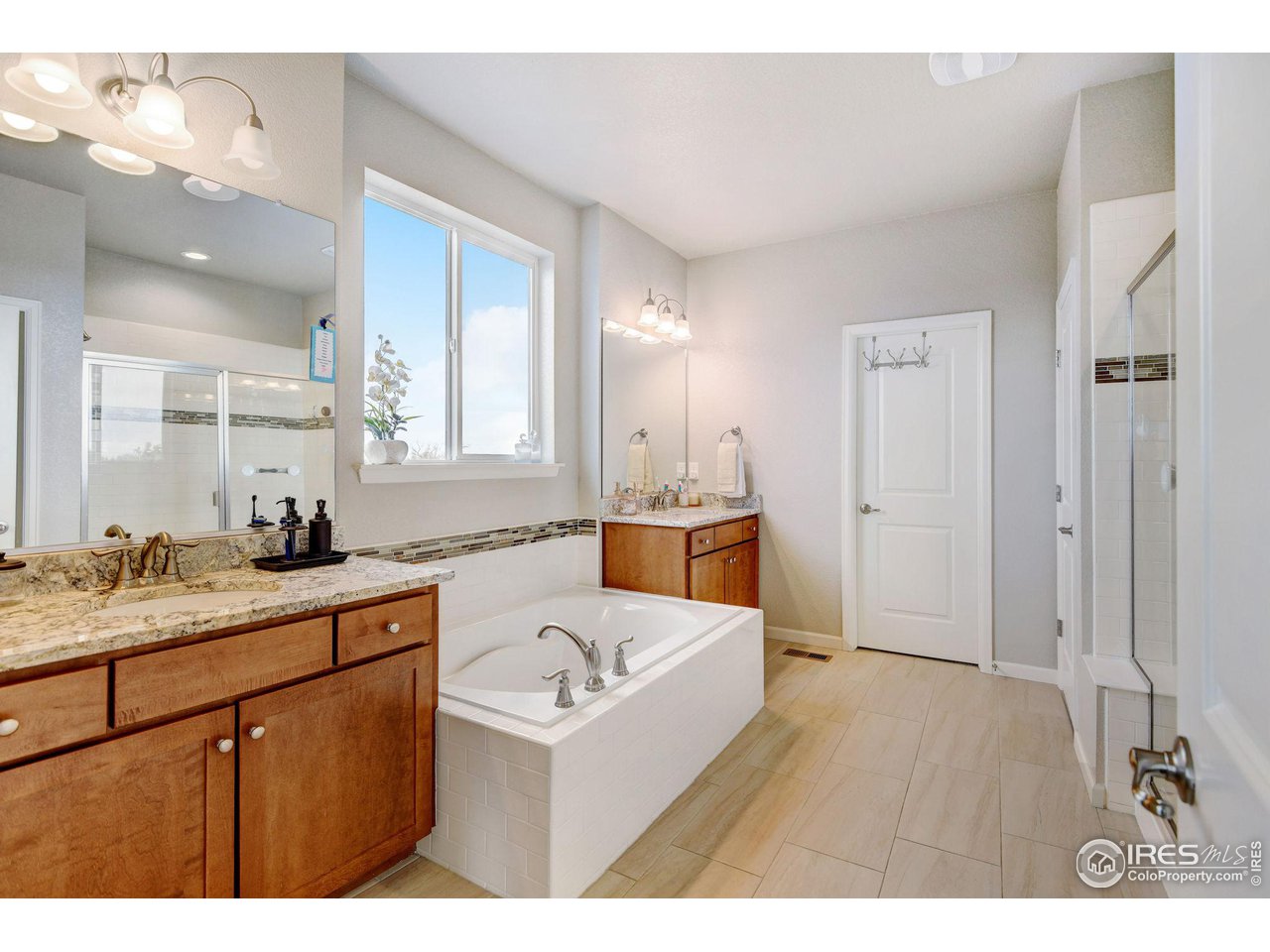 620 Wagon Bend Road Berthoud, CO 80513 - Photo 23 of 39 a bathroom with a sink double vanity granite tub shower and a mirror