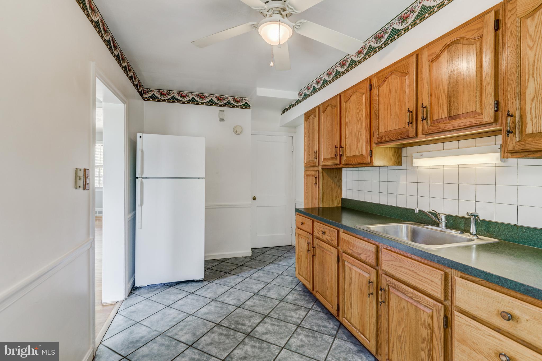 1265 Cedarcroft Road Baltimore, MD 21239 - Photo 12 of 21 a kitchen with granite countertop a sink a refrigerator and cabinets