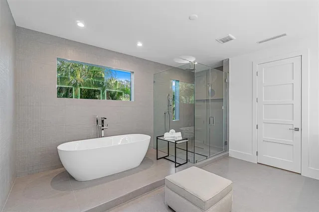 a bathroom with a white tub shower and sink
