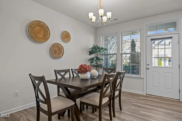 a view of a dining room with furniture chandelier and wooden floor