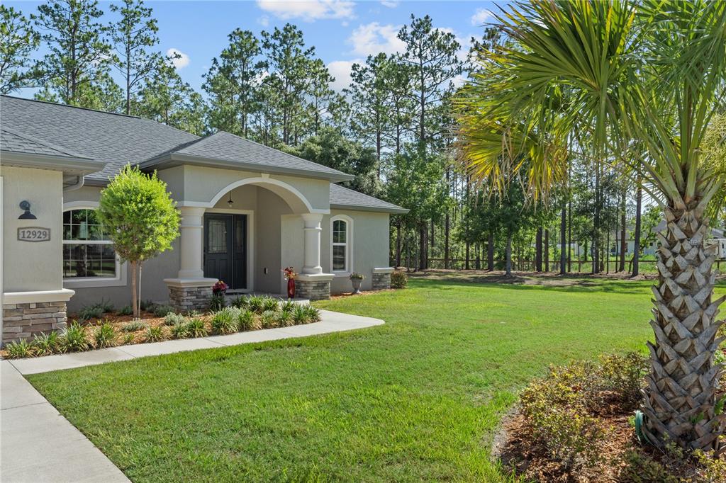 12929 Southwest 89th Street Dunnellon, FL 34432 - Photo 31 of 76 a front view of a house with garden