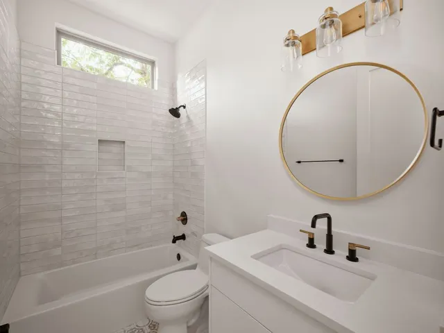 a bathroom with a sink a toilet and a mirror