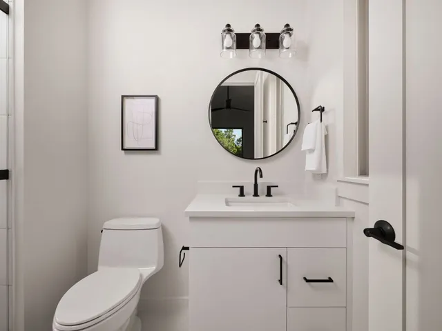 a bathroom with a toilet sink and mirror