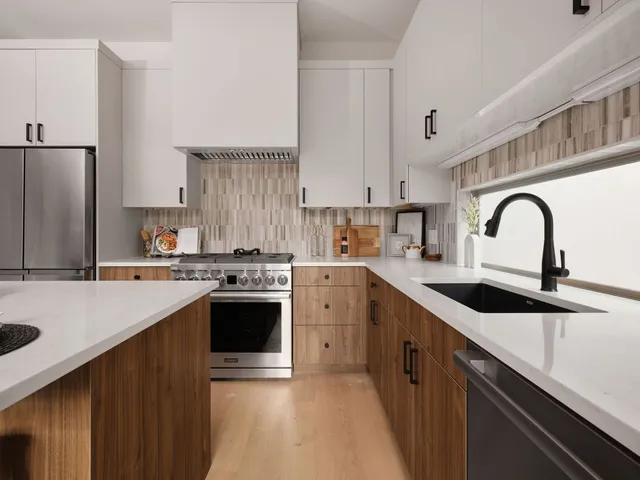 a kitchen with a sink a stove a refrigerator and cabinets
