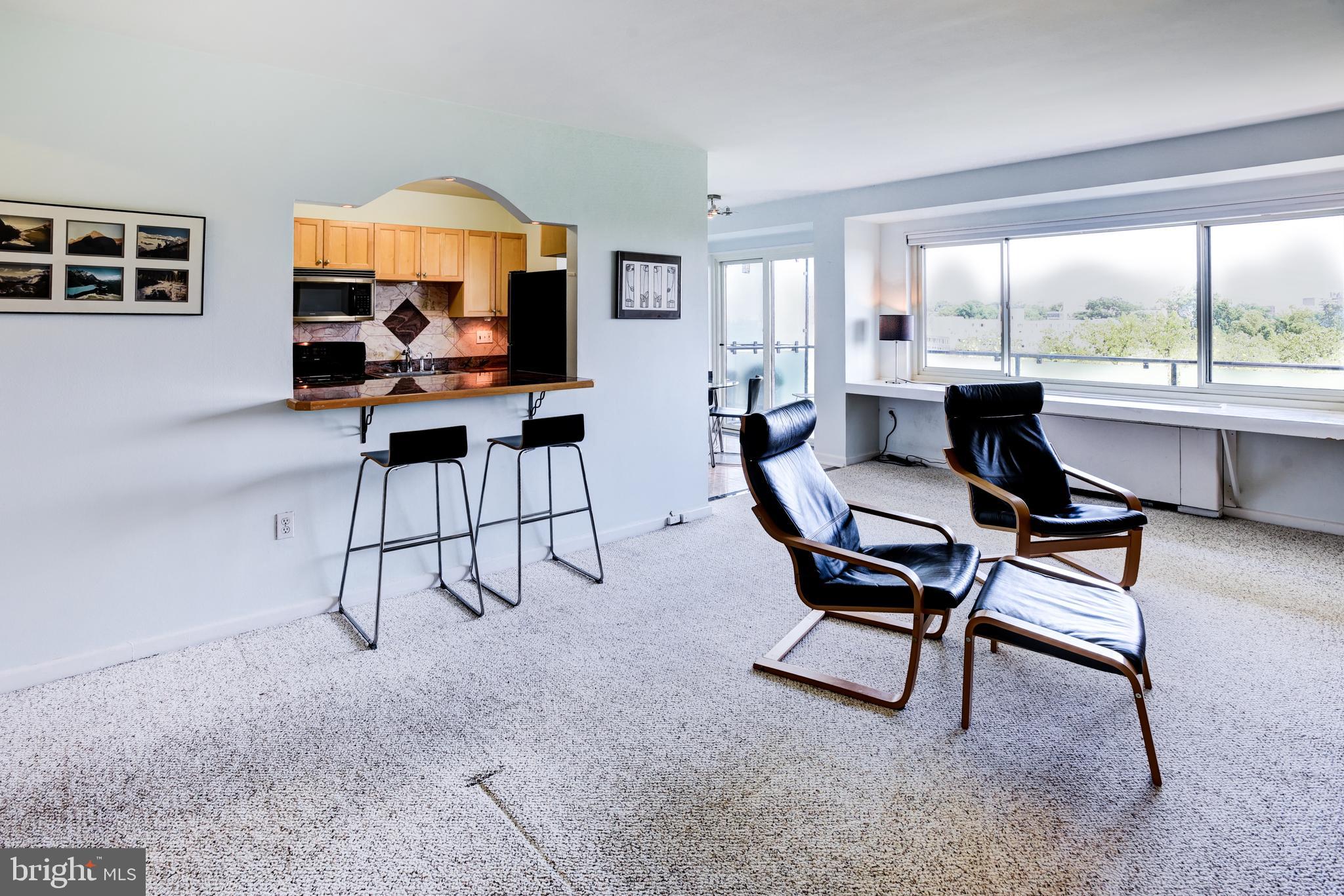 4201 Cathedral Avenue Northwest, Unit 1411E Washington, DC 20016 - Photo 17 of 66 a living room with furniture a large window and a flat screen tv