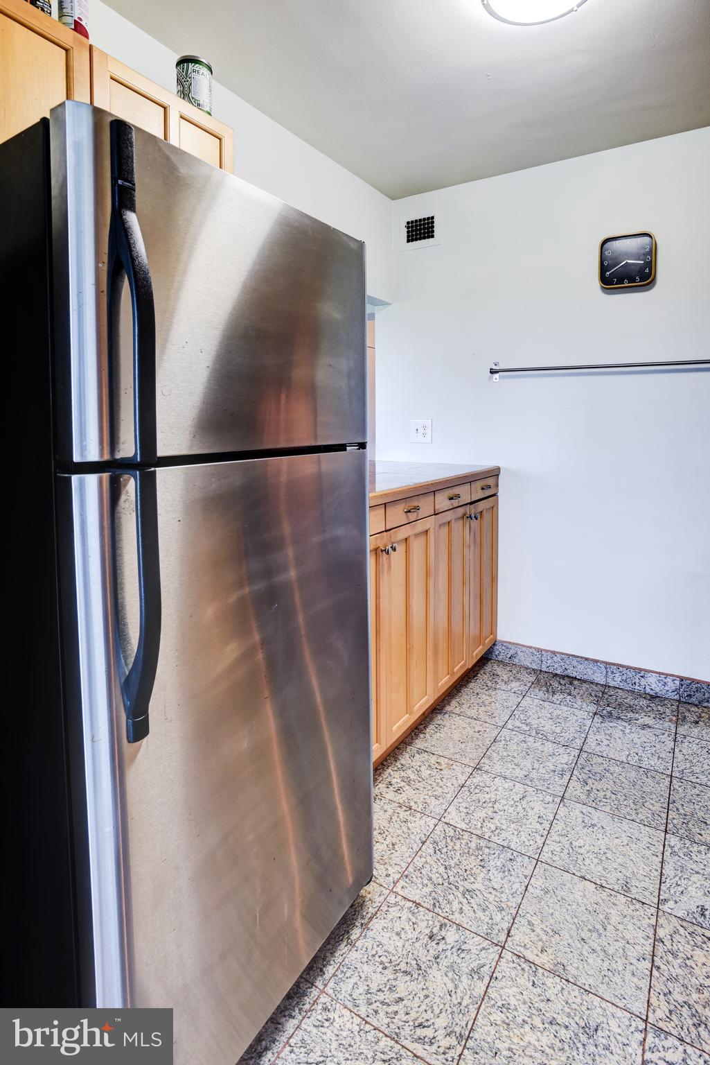 4201 Cathedral Avenue Northwest, Unit 1411E Washington, DC 20016 - Photo 26 of 66 a view of a refrigerator in kitchen and an empty room