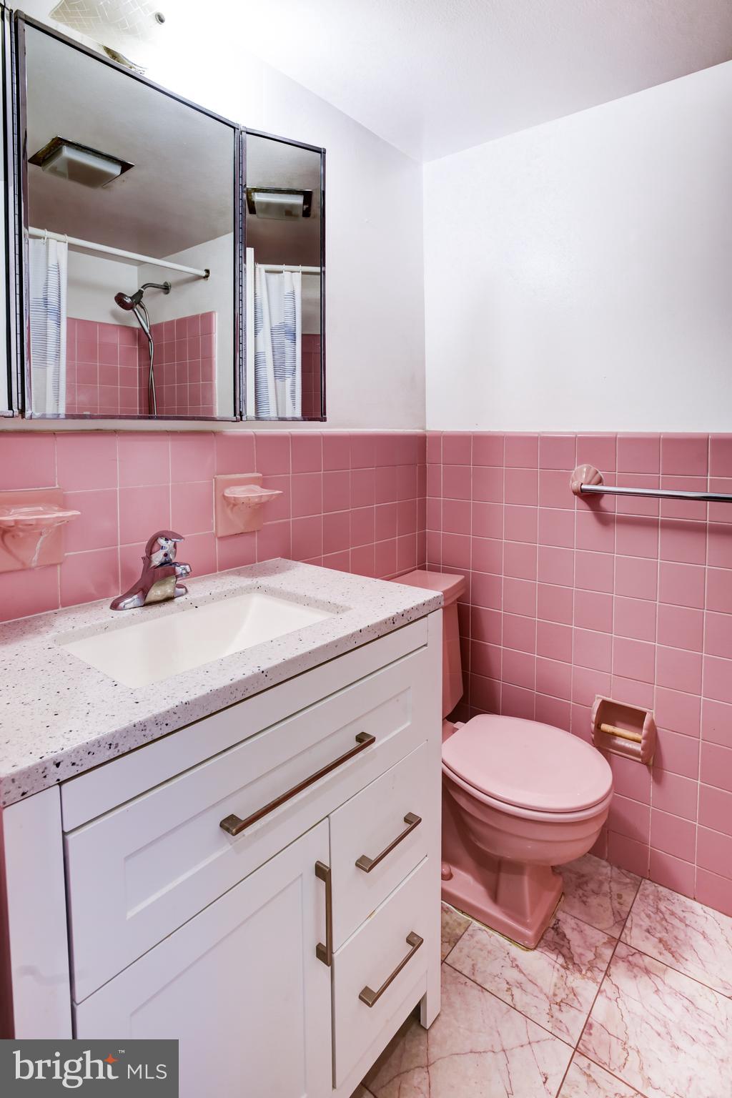 4201 Cathedral Avenue Northwest, Unit 1411E Washington, DC 20016 - Photo 38 of 66 a bathroom with a granite countertop toilet sink and mirror