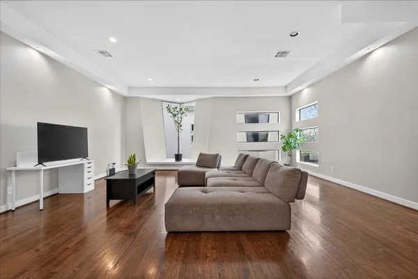 a living room with furniture flat screen tv and wooden floor