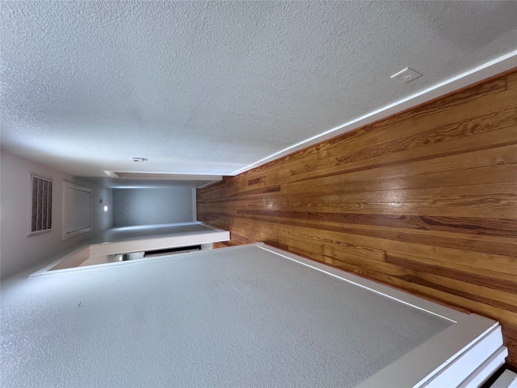 939 Knape Road La Grange, TX 78945 - Photo 20 of 37 Corridor with hardwood / wood-style flooring, a textured wall, and attic access